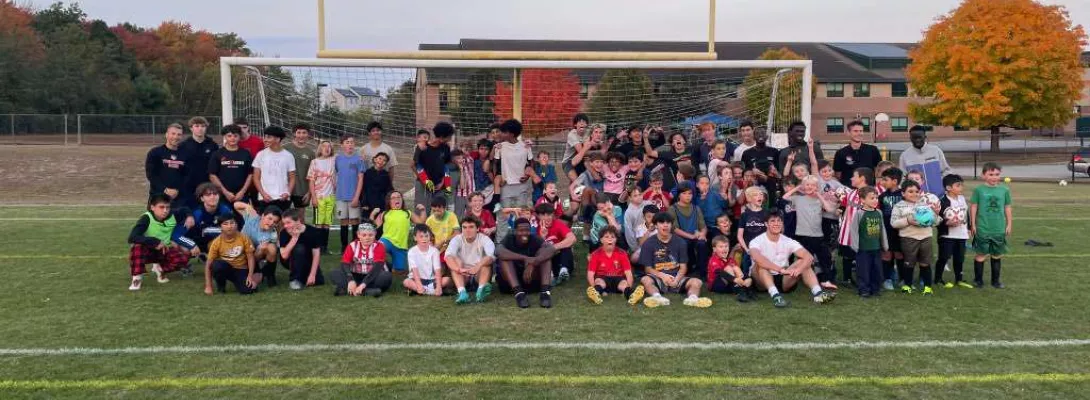 Picture of Tyngsboro High School Varsity team posing during training with the youth soccer program