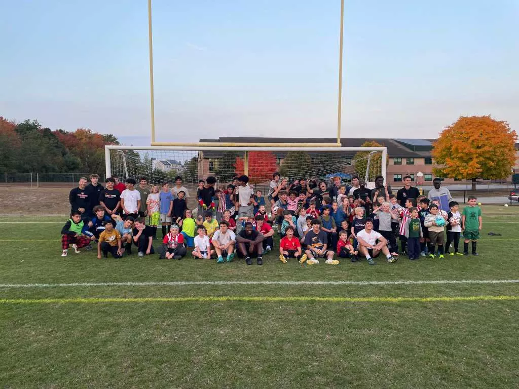 Picture of Tyngsboro High School Varsity team posing during training with the youth soccer program